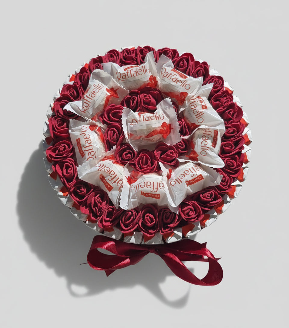 Coffret cadeau bouquet de chocolats Raffaello avec fausses roses rouges. Boîte ronde de gourmandises et décoration Saint-Valentin, fête des mères ou anniversaire. Ruban satin rouge.