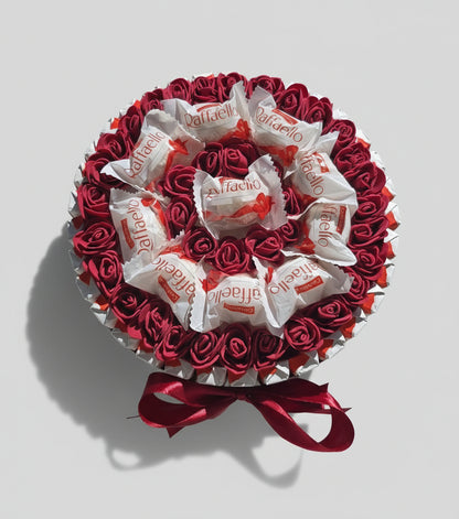 Coffret cadeau bouquet de chocolats Raffaello avec fausses roses rouges. Boîte ronde de gourmandises et décoration Saint-Valentin, fête des mères ou anniversaire. Ruban satin rouge.